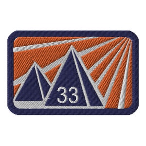 May include: A navy blue embroidered patch with a white outline. The patch features three stylized mountains with a white background and orange rays emanating from the top. The number 33 is centered in white.