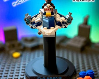 May include: A Lego Microfighter stand with a black base, holding a Lego starfighter model. The stand has a plaque that reads "Plo Koon's Jedi Starfighter Microfighter." The image also includes the text "Lego Microfighter Stands" and "Lego Microfighter Not Included."