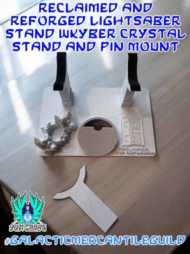 以下が含まれることがあります： 黒いアクセントが付いた白いライトセーバーのスタンド、クリスタルスタンド、ピンマウント。スタンドのテキストは「RECLAIMED AND REFORGED LIGHTSABER STAND WKYBER CRYSTAL STAND AND PIN MOUNT」と書かれています。画像にはロゴとハッシュタグ#GALACTICMERCANTILEGUILDも含まれています。