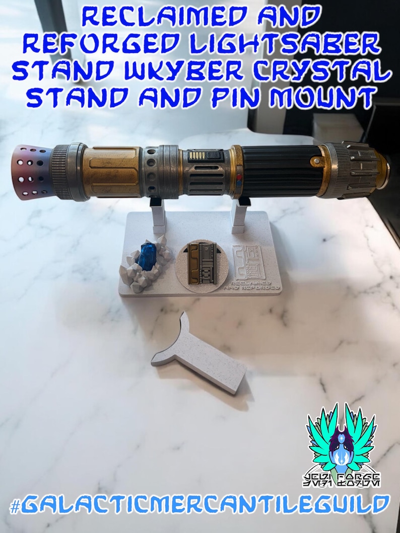 以下が含まれることがあります： 黒、金、銀色の柄のライトセーバーが、青いクリスタルとピンマウントが付いた白いスタンドに置かれています。「RECLAIMED AND REFORGED LIGHTSABER STAND WKYBER CRYSTAL STAND AND PIN MOUNT」というテキストが上部にあります。