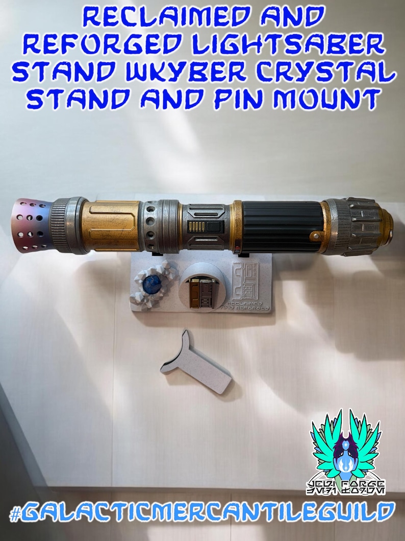 以下が含まれることがあります： 黒、金、銀色の柄のライトセーバーが白いスタンドに置かれています。スタンドには青いクリスタルとピンマウントも含まれています。上部のテキストには「RECLAIMED AND REFORGED LIGHTSABER STAND WKYBER CRYSTAL STAND AND PIN MOUNT」と書かれています。