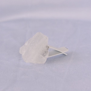 May include: A clear ice cube is held by a white plastic clip.