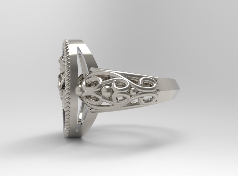 K&ouml;nnte beinhalten: Ein silberner Ring mit einem komplizierten Design. Der Ring hat ein breites Band mit einem dekorativen Filigranmuster. Der Ring ist oval geformt und hat eine glatte Oberfl&auml;che.