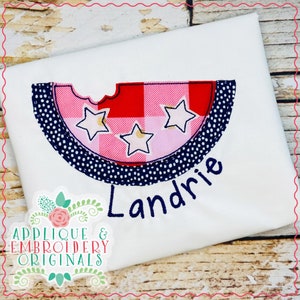 May include: A white t-shirt with a red, pink and blue watermelon applique featuring gold stars. The name "Landrie" is embroidered below the watermelon.