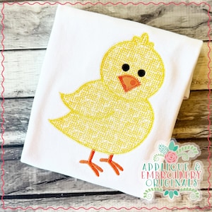 May include: A white fabric item featuring a yellow embroidered chick design. The chick has black eyes, an orange beak and feet. The design is outlined in yellow thread. The text "Applique & Embroidery Originals" is in the lower right corner.