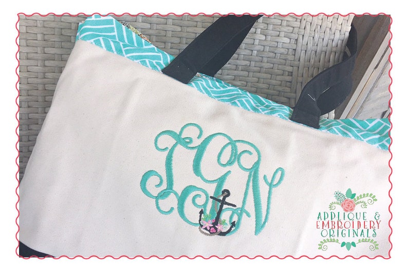 May include: A white canvas tote bag with a turquoise and white chevron pattern trim. The bag has black handles and a green embroidered monogram with an anchor and flowers. The text "Applique & Embroidery Originals" is embroidered on the bottom right corner of the bag.