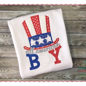 Op de afbeelding: Wit T-shirt met een geborduurd rood, wit en blauw Uncle Sam-hoedje en de tekst "all american BOY".