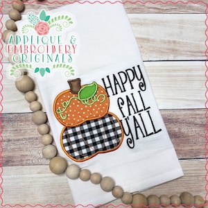 May include: White kitchen towel with an embroidered pumpkin design. The top pumpkin is orange with white polka dots, and the bottom pumpkin is black and white checkered. The text "HAPPY FALL Y'ALL" is embroidered in black.