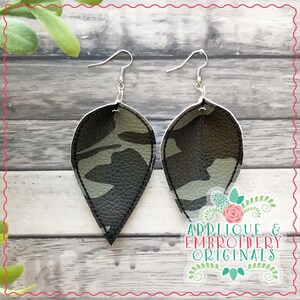 May include: A pair of dangle earrings with a camouflage pattern on a light gray background. The earrings are made of leather and have silver hooks.