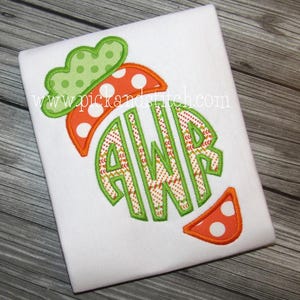 Puede incluir: Camiseta blanca con un diseño de zanahoria y las letras AWR en su interior. La zanahoria tiene lunares naranjas y blancos, hojas verdes y un borde verde. El sitio web www.pickandstitch.com es visible.