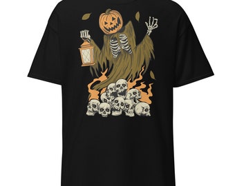 May include: Black t-shirt with a graphic of a skeleton wearing a jack-o-lantern head and holding a lantern. The skeleton is surrounded by a pile of skulls.
