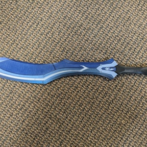 May include: A blue and black sword with a curved blade and a silver design. The sword is made of plastic and is a prop.