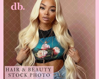 May include: A woman with long, flowing blonde hair wearing a black crop top with a floral print and blue jeans. The background is a pink and brown grid pattern.
