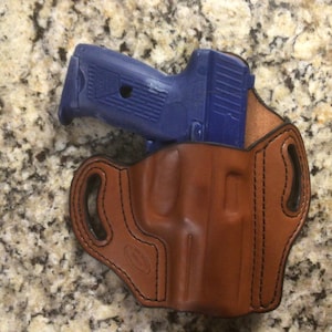 May include: A set of three ceramic canisters with lids. The canisters are white with a blue floral pattern. The largest canister is 8 inches tall, the medium is 7 inches, and the smallest is 6 inches.