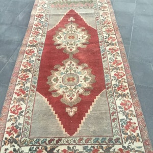 Puede incluir: Una alfombra vintage con un patr&oacute;n floral rojo, crema y azul. La alfombra tiene un centro en forma de diamante con un dise&ntilde;o floral y un borde con un patr&oacute;n floral.