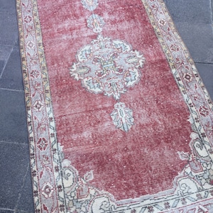 Pode incluir: Um tapete corredor vermelho vintage com um padr&atilde;o floral desbotado e uma borda branca. O tapete tem um visual desgastado e &eacute; perfeito para adicionar um toque de estilo bo&ecirc;mio &agrave; sua casa.