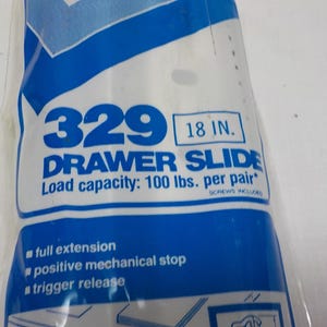 May include: A package for a drawer slide, with the number "329" in blue. The text "DRAWER SLIDE" is below, with "18 IN." in a box. Load capacity is 45 kg per pair. Features include full extension and trigger release. Screws included.
