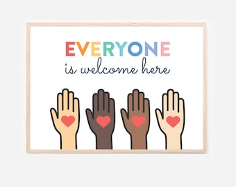 May include: A framed print with the text "EVERYONE is welcome here" in colorful letters. Below the text are four stylized hands of different skin tones, each with a red heart in the palm. The frame is a light wood color.
