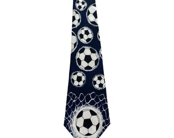 May include: A dark blue necktie with a white soccer ball pattern. The soccer balls are scattered across the tie and appear to be in a net.