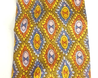May include: A patterned silk tie with a geometric design in shades of orange, yellow, blue, and white on a green background.