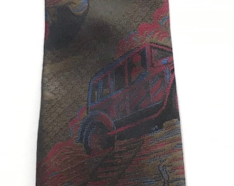 May include: A brown silk tie with a colorful pattern of cars, people, and geometric shapes. The tie has a pointed tip and a woven texture.