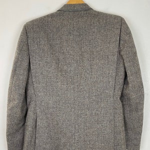 May include: A gray tweed blazer with a single button closure. The blazer has a classic fit and is made of a soft, comfortable fabric.