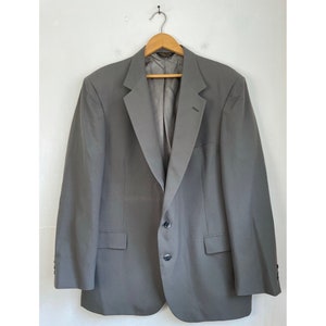 May include: A gray blazer with a single button closure and two pockets. The blazer has a classic, tailored fit.