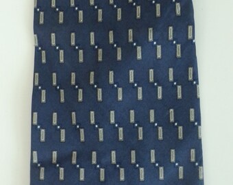 May include: A dark blue necktie with a white and gray geometric pattern.