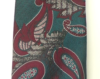 Könnte beinhalten: Eine grün-burgunderfarbene Krawatte mit Paisley-Muster. Die Krawatte hat eine spitze Spitze und eine gewebte Textur.