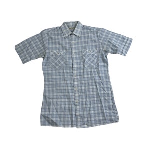 Op de afbeelding: Een blauw-wit geruit overhemd met korte mouwen en twee borstzakken.