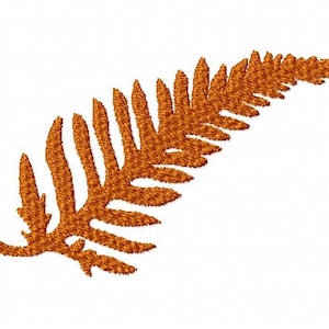May include: An embroidered fern leaf in shades of orange and brown. The fern is a detailed design, with each leaflet clearly defined. The image is set against a plain white background, highlighting the intricate details of the fern.