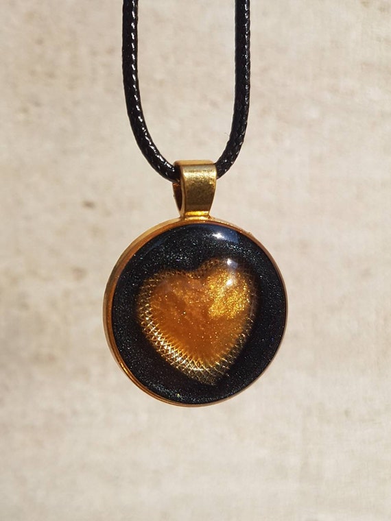 Necklace with round pendant: golden heart in metallic black epoxy resin