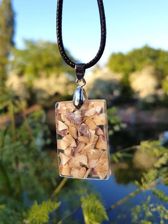 Necklace with pendant with slightly glittering shell fragments in transparent epoxy resin