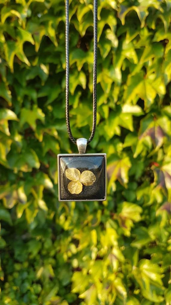 Necklace with pendant - amulet with delicate flower cast in metallic black epoxy resin and square setting in silver