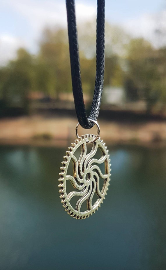 Black necklace with silver pendant - gear with sun swirl