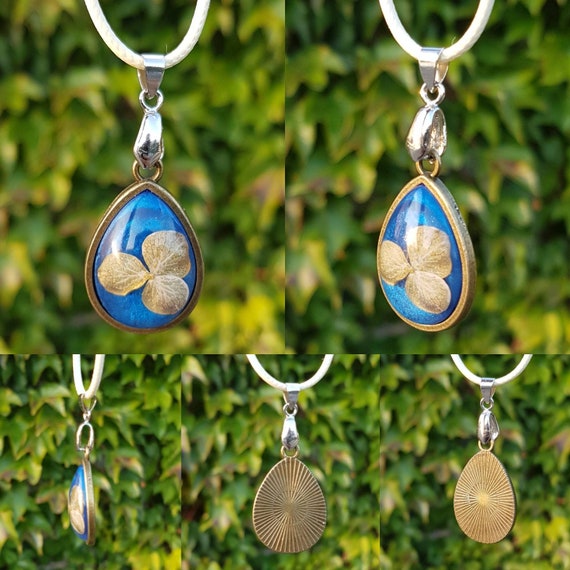 Necklace with pendant - amulet with delicate flower cast in metallic blue epoxy resin and setting in bronze