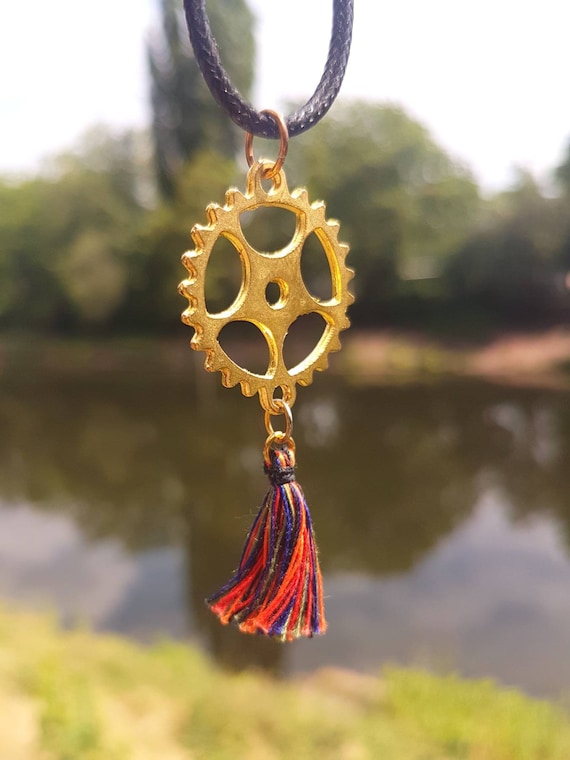 Black chain with golden steampunk gear and attached colorful tassel (red, blue, green, black, orange)