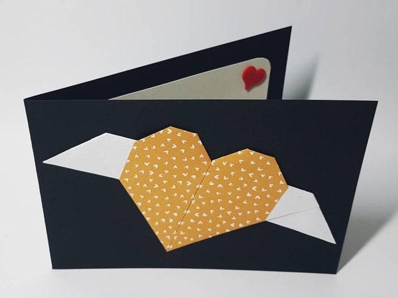 Black folding card with orange origami heart with white wings