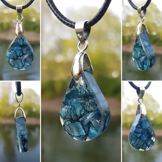 Necklace with pendant with slightly glittering blue shell fragments in transparent epoxy resin