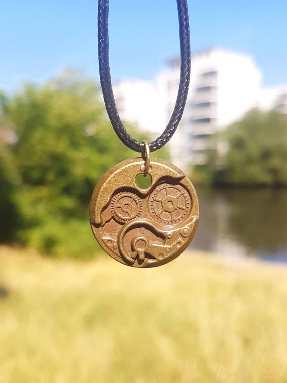 Black chain with bronze-colored round pendant - gears in industrial design