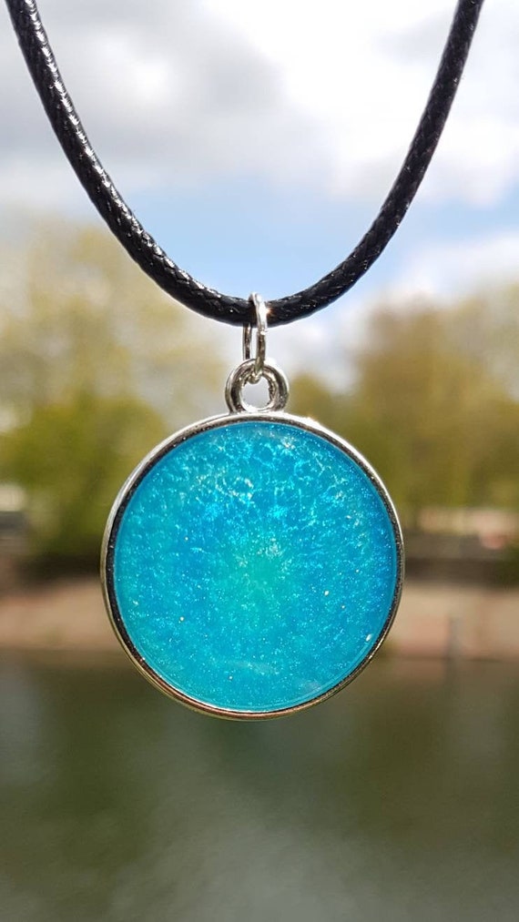 Necklace with round pendant made of epoxy resin metallic: turquoise blue like the Caribbean in a silver frame