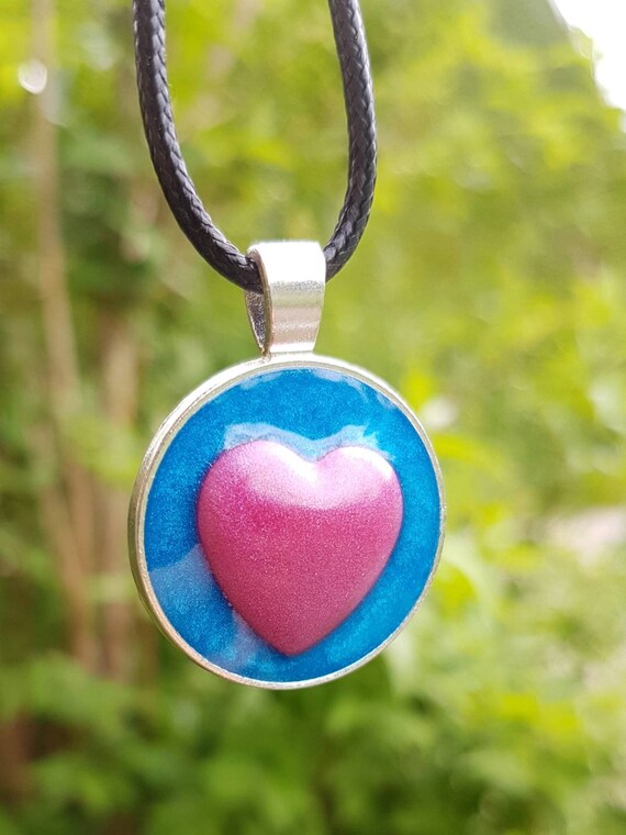 Necklace with round pendant: pink heart in metallic blue - made of epoxy resin - setting in silver
