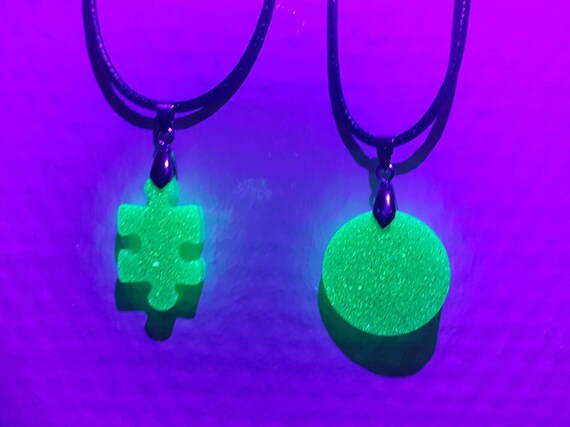 Necklace with pendant made of epoxy resin - puzzle piece in neon green with UV color - glows under black light!