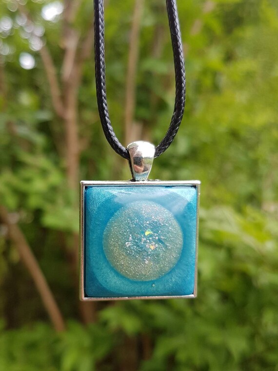 Necklace with amulet pendant: silver glittering circle in metallic blue epoxy resin - square setting in silver