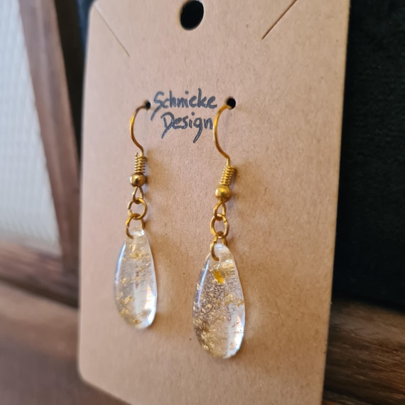Earrings made of transparent epoxy resin with gold leaf.