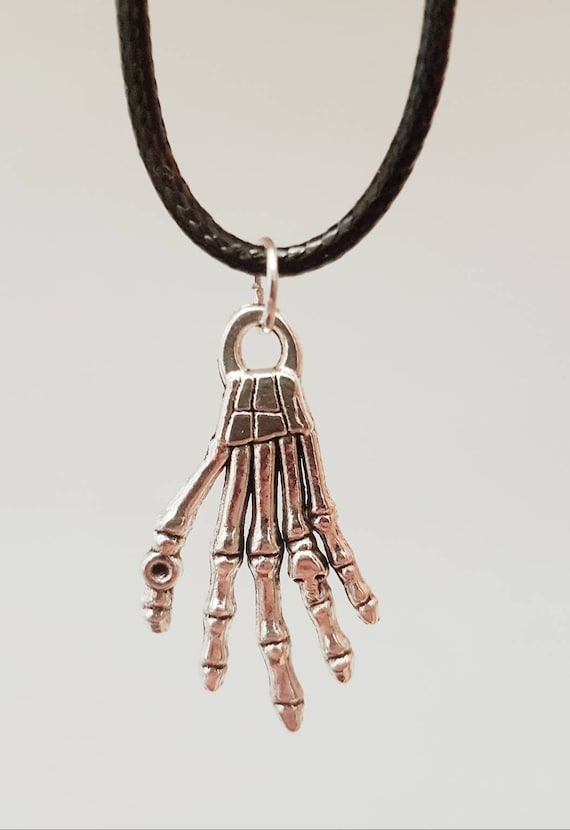 Black necklace with small silver skeleton hand as pendant