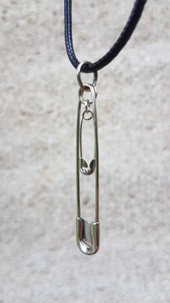 Black chain with two interlocking silver safety pins as pendants