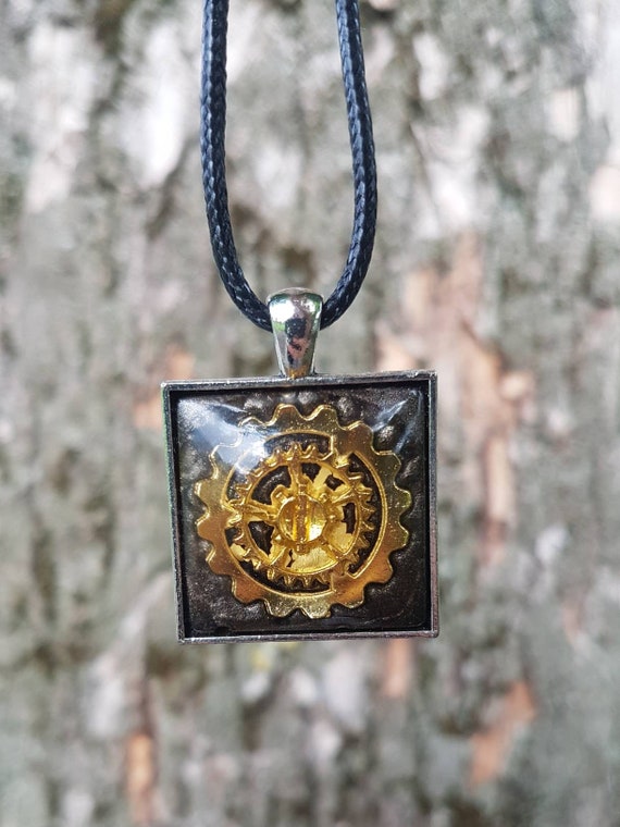Necklace with square pendant: silver amulet with golden gear cast in metallic black epoxy resin