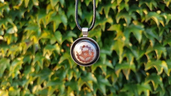 Necklace with round pendant: silver amulet with gear in bronze on metallic silver and black epoxy resin