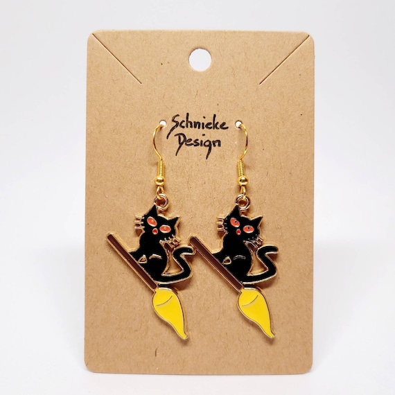 Earrings with black cats on witches' brooms
